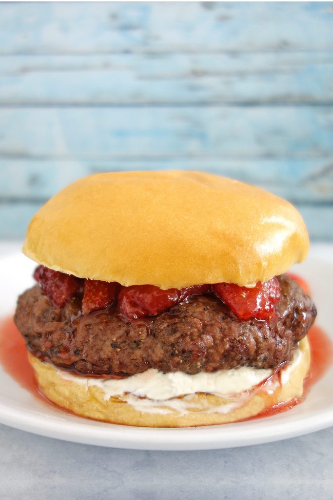 The strawberry french toast burger has a french toasted bun, cream cheese and is topped with strawberries.